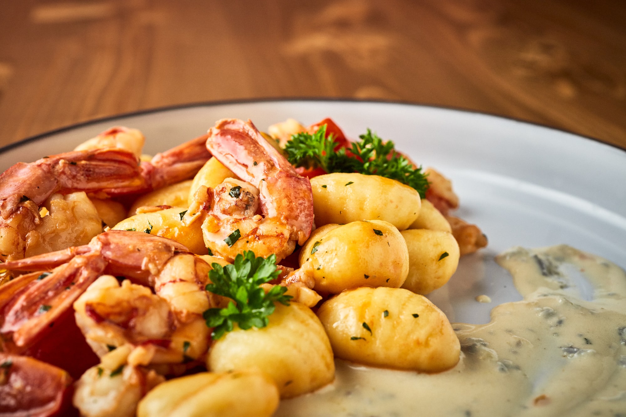 Włoskie gnocchi podane w kremowym sosie z krewetakmi i surową natką pietruszki.